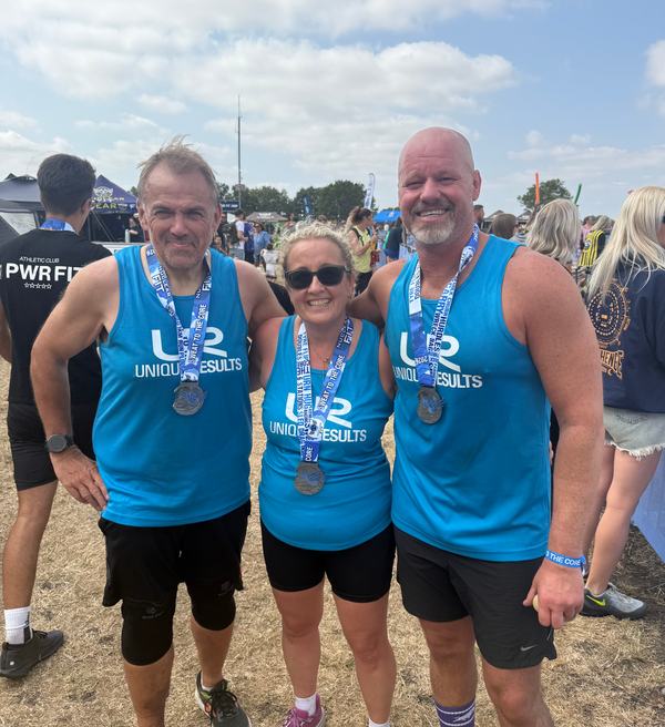 Unique Results members wearing their medals after completing a fitness event