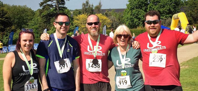 Unique Results members with their medals after a charity race