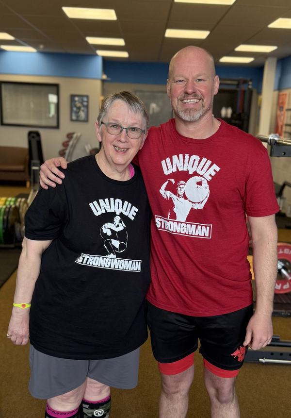 A Unique Results member and coach in their Unique Strongman shirts